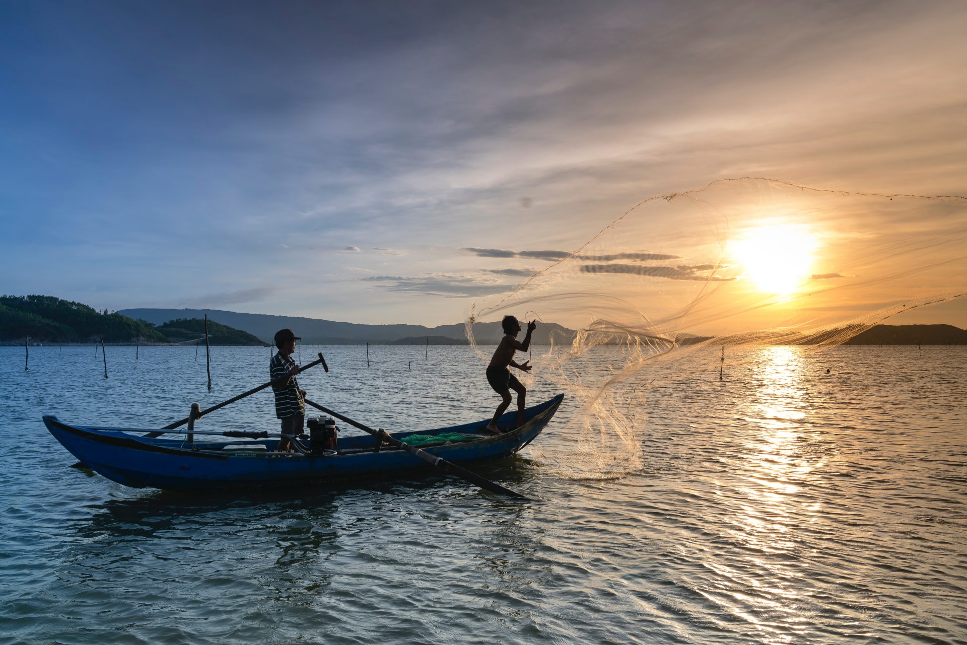 silhouette-photo-of-two-men-riding-a-boat-2163224